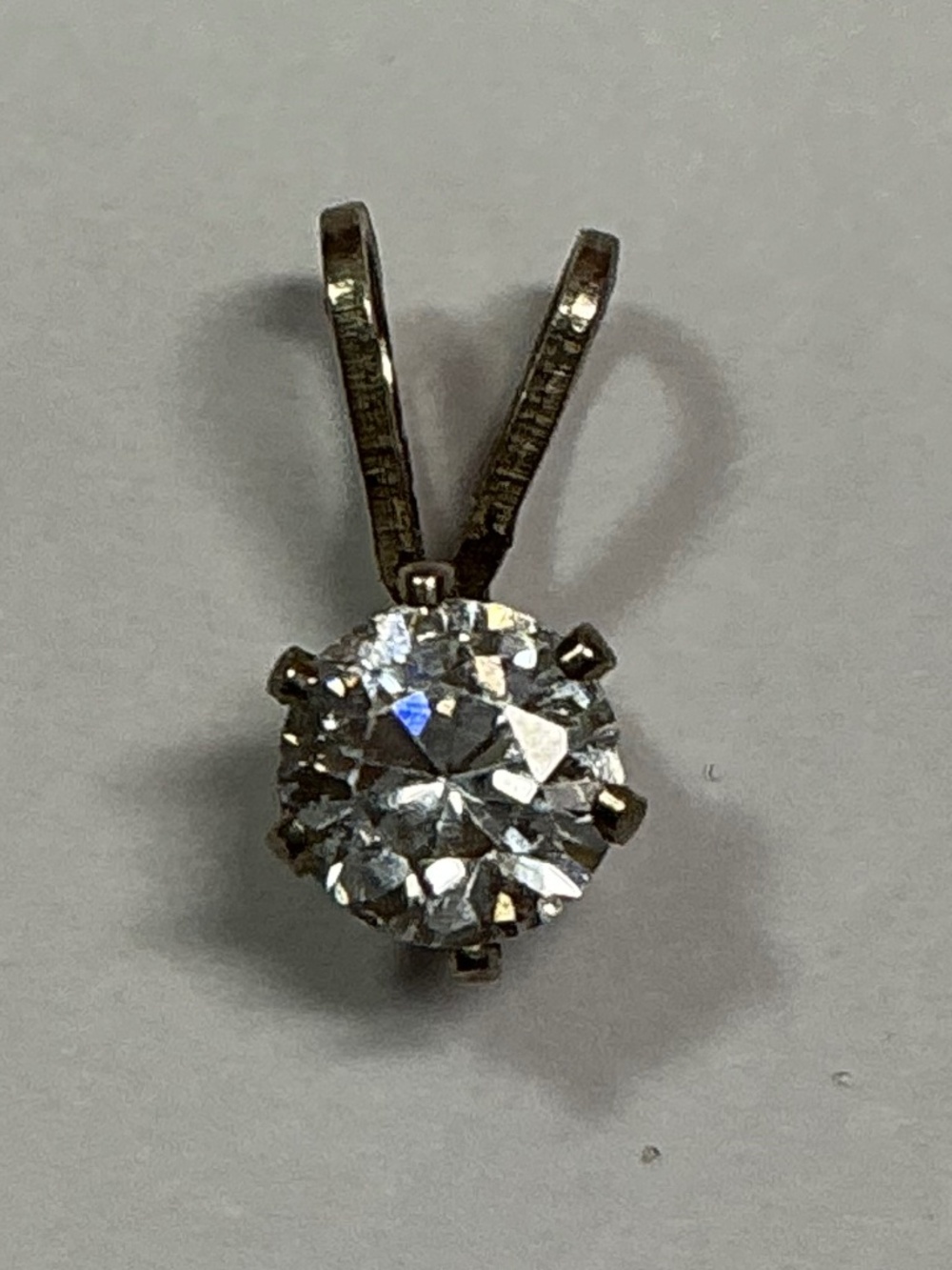 Sterling Silver Petite Pendant with a clear stone. 1/2 inches long